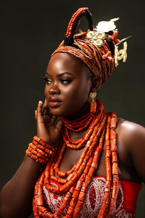 Free Beautiful portrait of a Nigerian woman in elaborate traditional attire with vibrant coral beads, showcasing cultural elegance. Stock Photo